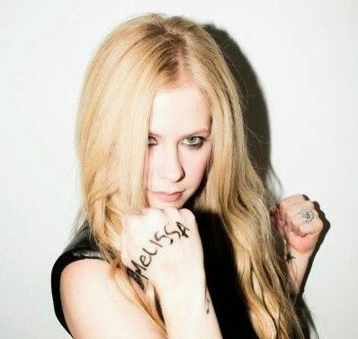 A photoshoot picture of Avril Lavigne with 'Melissa' written on her hand